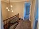 Hallway featuring carpet flooring, staircase, and modern light fixture, creating an inviting and functional space at 1414 Stickley Ave, Kissimmee, FL 34747