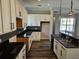 Spacious kitchen with sleek black countertops, white cabinets, and modern hanging pendant lights at 1414 Stickley Ave, Kissimmee, FL 34747