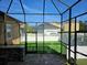 View of the backyard from the screened-in patio, showcasing green grass, a white fence, and nearby homes at 1414 Stickley Ave, Kissimmee, FL 34747