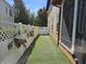Artificial grass in the side yard, enclosed by a white lattice fence and the home's exterior at 1414 Stickley Ave, Kissimmee, FL 34747