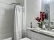 This bathroom has a tiled shower, with a nice vanity with a red flower accent at 1418 Kissimmee Ct, Kissimmee, FL 34759