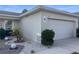 View of two car garage with decorated garden bed at 1418 Kissimmee Ct, Kissimmee, FL 34759