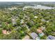 Expansive aerial view of a leafy residential area, showcasing homes with pools near a serene lake and city skyline at 1420 Palmer Ave, Winter Park, FL 32789