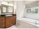 Elegant bathroom featuring a soaking tub, granite countertops, and a window for natural light at 1420 Palmer Ave, Winter Park, FL 32789
