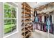 Walk-in closet with built-in wooden shelving, closet rod, and large window with lawn view at 1420 Palmer Ave, Winter Park, FL 32789