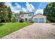 Inviting two-story home featuring a well-manicured lawn, blue shutters and a paver driveway leading to a two-car garage at 1420 Palmer Ave, Winter Park, FL 32789