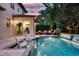 Luxurious backyard pool area with outdoor seating, lush landscaping, and a tranquil waterfall feature at 1420 Palmer Ave, Winter Park, FL 32789