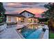 Backyard pool with stone deck, outdoor seating, and a view of the home's exterior at sunset at 1420 Palmer Ave, Winter Park, FL 32789