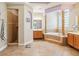 Luxurious bathroom featuring a soaking tub, tiled shower, double vanities, and decorative columns at 1429 Arbitus Cir, Oviedo, FL 32765