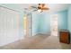 Aqua bedroom with a ceiling fan, closet, and a glimpse into the en-suite bathroom at 1429 Arbitus Cir, Oviedo, FL 32765