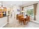 Charming dining area with a wood table set, pendant lighting, and a large window overlooking the pool at 1429 Arbitus Cir, Oviedo, FL 32765