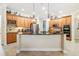 Well-equipped kitchen with wood cabinetry, a black countertop island, pendant lighting, and stainless steel appliances at 1429 Arbitus Cir, Oviedo, FL 32765