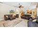 Bright living room featuring leather sofas, a ceiling fan, and an open floor plan connected to the kitchen at 1429 Arbitus Cir, Oviedo, FL 32765