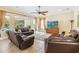 Spacious living room with tile flooring, comfortable leather furniture, and backyard views at 1429 Arbitus Cir, Oviedo, FL 32765