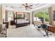 Spacious main bedroom featuring a four-poster bed, tray ceiling with fan, and natural light from large windows at 1429 Arbitus Cir, Oviedo, FL 32765
