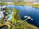 Scenic aerial view of a lakeside resort featuring pools, docks, lush landscaping, and beautiful natural surroundings at 14501 Grove Resort Ave # 2451, Winter Garden, FL 34787