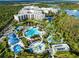 Stunning aerial view of a luxury resort, showcasing its expansive pools, lush landscaping, and serene lakeside setting at 14501 Grove Resort Ave # 2451, Winter Garden, FL 34787