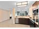 Open kitchen layout with stainless steel dishwasher, stove, and view into the living area and balcony at 14501 Grove Resort Ave # 2451, Winter Garden, FL 34787