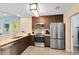Well-equipped kitchen featuring stainless steel appliances and wood cabinetry for a modern aesthetic at 14501 Grove Resort Ave # 2451, Winter Garden, FL 34787