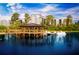 Picturesque lake view featuring a charming gazebo on a pier and swan paddle boats under a sunny sky at 14501 Grove Resort Ave # 2451, Winter Garden, FL 34787