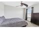 This bedroom features neutral walls, a modern ceiling fan and dark wood furnishings for a comfortable space at 15096 Chapter Way, Winter Garden, FL 34787