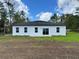 Image of backyard featuring freshly sodded yard, black roof, white stucco, and new windows at 16463 Sw 55Th Court Rd, Ocala, FL 34473