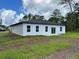Image of backyard featuring freshly sodded yard, black roof, white stucco, and new windows at 16463 Sw 55Th Court Rd, Ocala, FL 34473