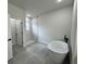 Modern bathroom featuring gray tile floors, a walk-in shower, and a standalone soaking tub at 16463 Sw 55Th Court Rd, Ocala, FL 34473