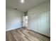 This is a bedroom with wood-look flooring and a closet with folding doors at 16463 Sw 55Th Court Rd, Ocala, FL 34473