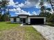 Charming single-story home with a black two-car garage and beautifully paved driveway at 16463 Sw 55Th Court Rd, Ocala, FL 34473