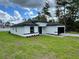 Charming single-story home featuring a black roof, white stucco exterior, and well-manicured front yard at 16463 Sw 55Th Court Rd, Ocala, FL 34473