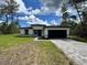 Charming single-story home with a black two-car garage and beautifully paved driveway at 16463 Sw 55Th Court Rd, Ocala, FL 34473