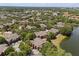 An aerial view of a community with lush landscaping, mature trees, and a tranquil lake at 173 Villa Di Este Ter # 209, Lake Mary, FL 32746
