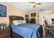 Comfortable bedroom with wood floors, ceiling fan, and large bed with blue quilt at 173 Villa Di Este Ter # 209, Lake Mary, FL 32746
