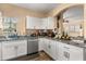 Bright kitchen featuring white cabinets, granite countertops, and stainless steel appliances at 173 Villa Di Este Ter # 209, Lake Mary, FL 32746