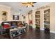 Cozy living room with hardwood floors, built-in shelving and comfortable leather couch at 173 Villa Di Este Ter # 209, Lake Mary, FL 32746