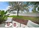 Serene backyard with a sprawling lawn, mature shade tree, and a privacy fence at 2306 Valhalla Dr, Tavares, FL 32778