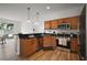 Well-lit kitchen with stainless steel appliances, granite countertops, and light wood cabinetry, open to living area at 2306 Valhalla Dr, Tavares, FL 32778