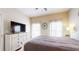 Bedroom featuring a dresser, a large TV, and a bed with a brown comforter at 2411 Caravelle Cir, Kissimmee, FL 34746