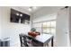 Dining area features a dark wood table, large window with a view, and a television on the wall at 2411 Caravelle Cir, Kissimmee, FL 34746