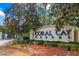 A welcoming community entrance with lush landscaping and prominent signage at 2411 Caravelle Cir, Kissimmee, FL 34746