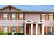 Charming townhome featuring a symmetrical facade, brown shutters, and private front entrances with white pillars at 2411 Caravelle Cir, Kissimmee, FL 34746
