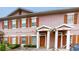 Charming townhome featuring a symmetrical facade, brown shutters, and private front entrances with white pillars at 2411 Caravelle Cir, Kissimmee, FL 34746