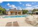 Community pool area featuring ample lounge chairs, a clubhouse, and a gazebo at 2411 Caravelle Cir, Kissimmee, FL 34746