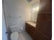 Clean bathroom featuring wood vanity, granite countertop, framed mirror, and a toilet, optimizing space at 2426 Windward Way, Winter Park, FL 32792