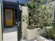 Inviting front entrance with yellow door, black iron gate, and lush landscaping at 2426 Windward Way, Winter Park, FL 32792