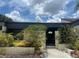 Charming home's entrance with a gated courtyard and lush landscaping under a partly cloudy sky at 2426 Windward Way, Winter Park, FL 32792