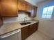 Functional kitchen with granite countertop, stainless steel sink, wood cabinets and a window for natural light at 2426 Windward Way, Winter Park, FL 32792