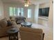 Bright living room with white tile floors, ceiling fan, and large windows at 2426 Windward Way, Winter Park, FL 32792