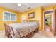 A yellow bedroom featuring a queen bed, window, and light-colored carpet at 2518 Fort Lane Rd, Geneva, FL 32732